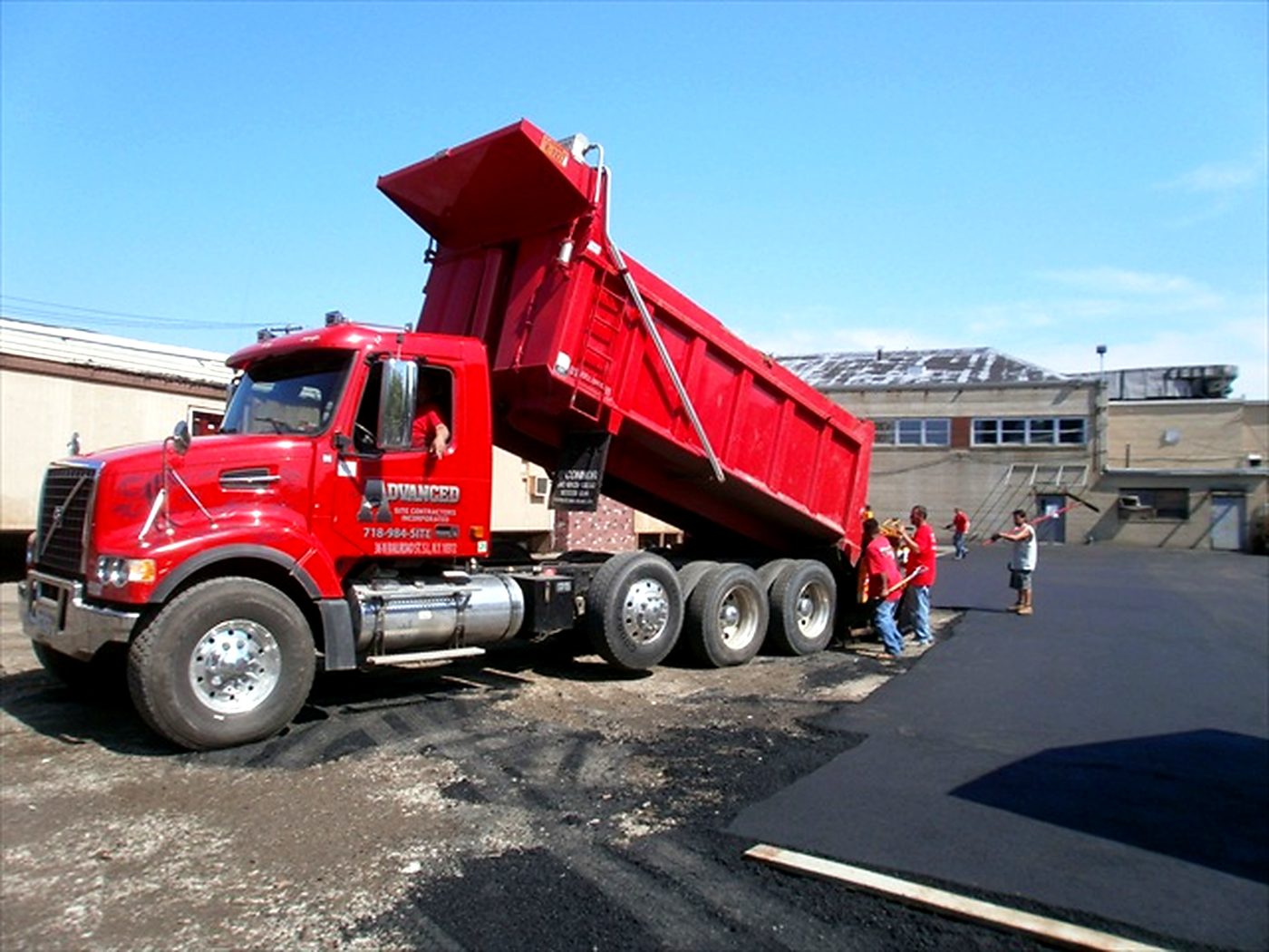 An Advanced Site Contractors haul truck and crew on a commercial paving job